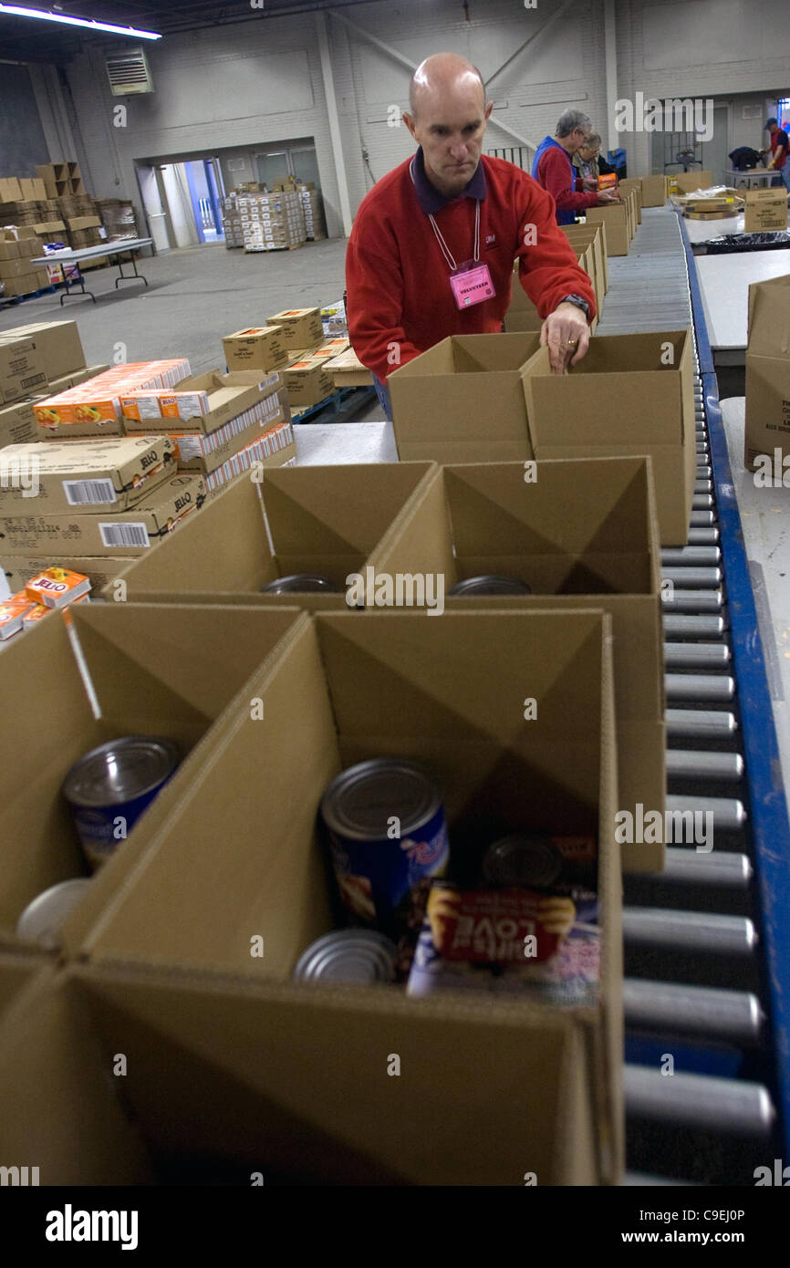 London, Ontario, Canada - le 8 décembre 2011. Chris Lanooy avances boîtes contenant des paniers de Noël 2011 à l'Armée du salut et de jouets de nourriture Distribution center à l'intérieur de la construction au Western Fair District. Cette année, l'Armée du Salut s'attend à fournir de la nourriture et des paniers de jouets t Banque D'Images