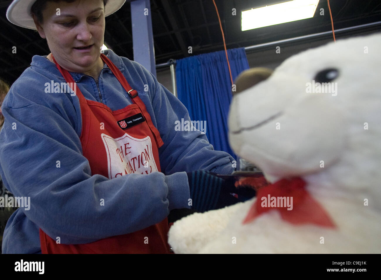 London, Ontario, Canada - le 8 décembre 2011. Kelley Thompson inspecte les jouets avant qu'ils sont emballés dans des paniers de jouets de Noël 2011 à l'Armée du salut et de jouets de nourriture Distribution center à l'intérieur de la construction au Western Fair District. Cette année, l'Armée du Salut s'attend à fournir de la nourriture Banque D'Images