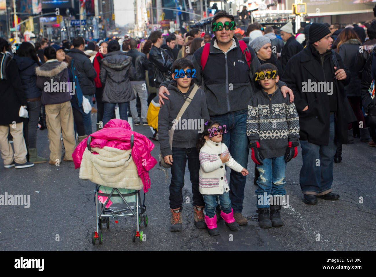 Une famille portant des lunettes 2012 a leur photo prise parmi la foule à New York Times Square le soir du Nouvel An 2011. Plus d'un million de personnes se joindront à la célébration d'accueillir 2012 à la Big Apple. Banque D'Images