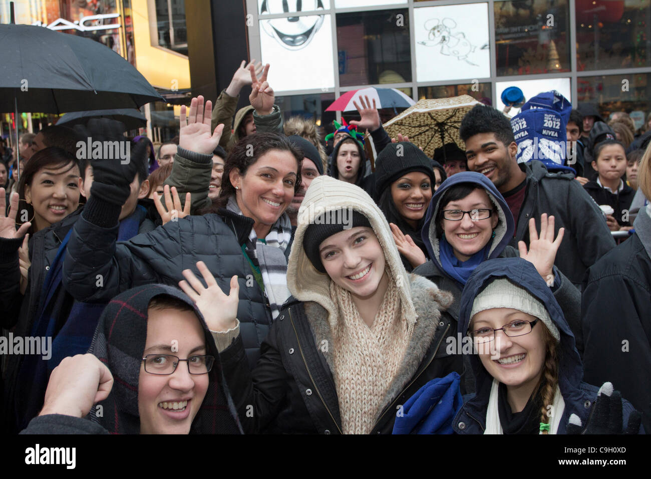 Smiling foule à New York Times Square attend l'arrivée de 2012 pour le Nouvel An. Plus d'un million de personnes de partout dans le monde finira par rejoindre la célébration dans la Big Apple. Banque D'Images