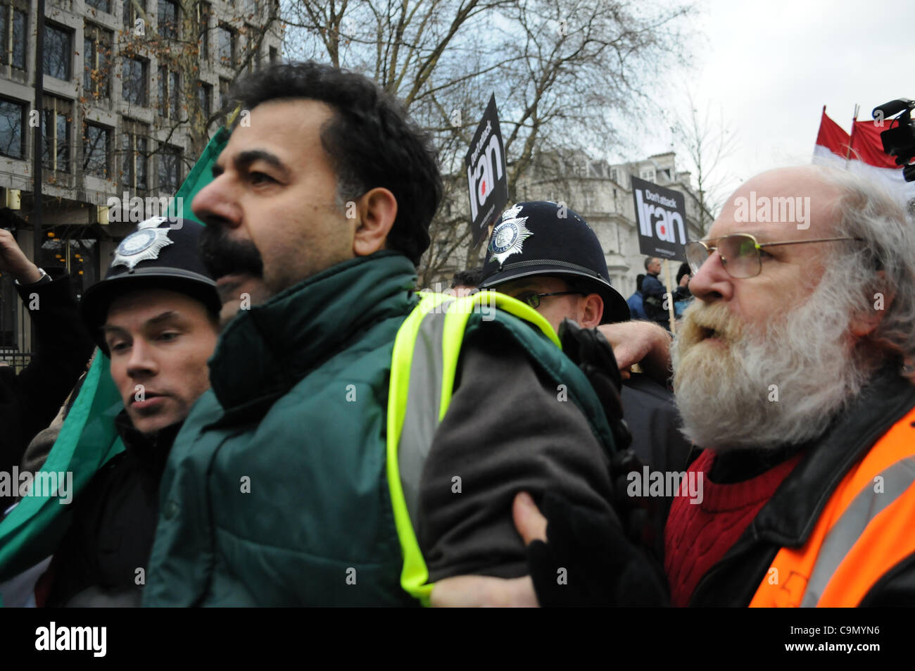 Londres, Royaume-Uni. 28/01/12. Un militant anti-Khomeiny est éjecté de la foule par la police et les stewards ont rencontré des centaines de Coalition contre la guerre manifestants devant l'ambassade des États-Unis à Londres. Banque D'Images