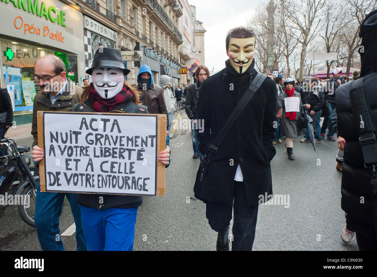 Grande foule de gens, marchant avec des panneaux de protestation, Anonymous protestant contre la loi anti-piratage d'Internet, ACTA (anti-Counterfeiting Trade Agreement), qui menace la liberté de l'Internet, Paris, France, français hommes Banque D'Images