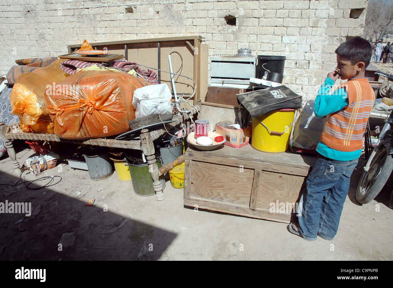 Un enfant regarde les ménages à ciel ouvert après son quart a été démoli lors de l'entraînement du ministère des chemins de fer contre les atteintes à Quetta le Jeudi, Février 09, 2012. Banque D'Images