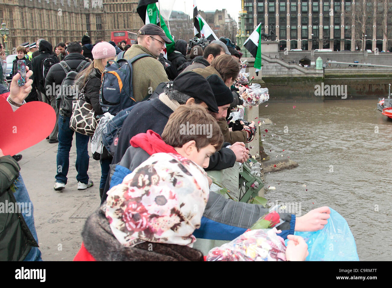 Les manifestants jettent syrienne roses et de fleurs de Westminster Bridge pendant un événement appelé Roses pour Martyrs. Banque D'Images