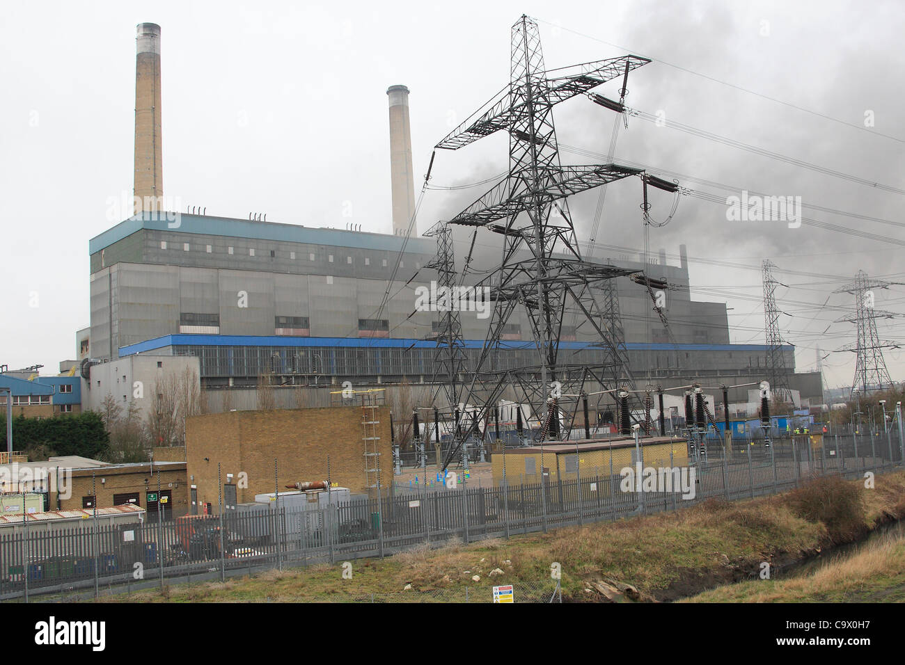 Tilbury, UK. 27 févr., 2012. Fumée noire et verse de la vapeur d'une centrale à Tilbury, Essex, après un grave incendie a éclaté. Plus de 100 pompiers sont la lutte contre l'incendie. Il est rapporté que le feu a démarré dans une trémie granulés de bois contenant environ 2 000 tonnes de carburant. Banque D'Images