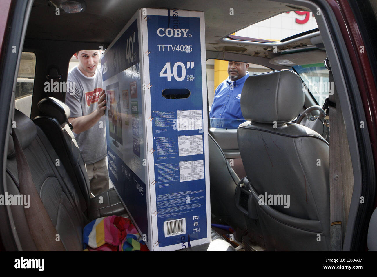 28 févr. 2012 - Memphis, Tennessee, États-Unis - 28 février 2012 - David Dupree met un grand écran plat dans la voiture de Danny Mull qui a dit qu'il venait de déménager et qu'il voulait des nouvelles choses. Les tendances montrent la confiance des consommateurs à être montée dans les derniers rapports.Ils étaient à HH Gregg près de Wolfchase. (Cred Banque D'Images