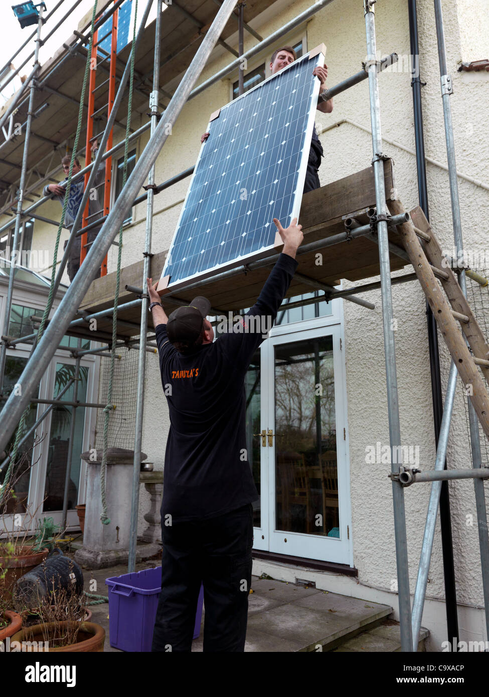 Des panneaux solaires étant insalled dans une maison dans le Surrey en Angleterre dans l'espoir de battre le cut par à paiement qui vient en vigueur cette semaine après le 2 mars 2012 Banque D'Images