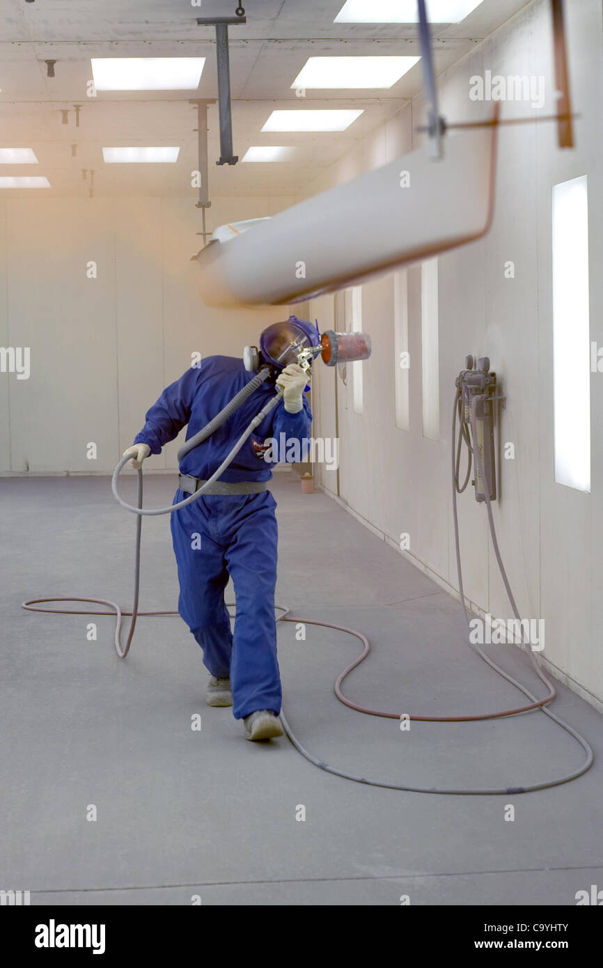London, Ontario, Canada - le 5 mars 2012. Steve Mann s'applique couches de peinture sur la coque de course unique dans la peinture, à Hudson Boat Works. Banque D'Images