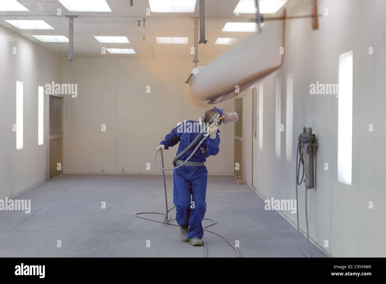London, Ontario, Canada - le 5 mars 2012. Steve Mann peint le dessous d'un seul homme racing coque. Boat Works Hudson a été building high performance course depuis 1981. Situé à London, Ontario Canada l'entreprise fournit des bateaux pour les équipes olympiques et nationales à travers le monde ainsi que Banque D'Images