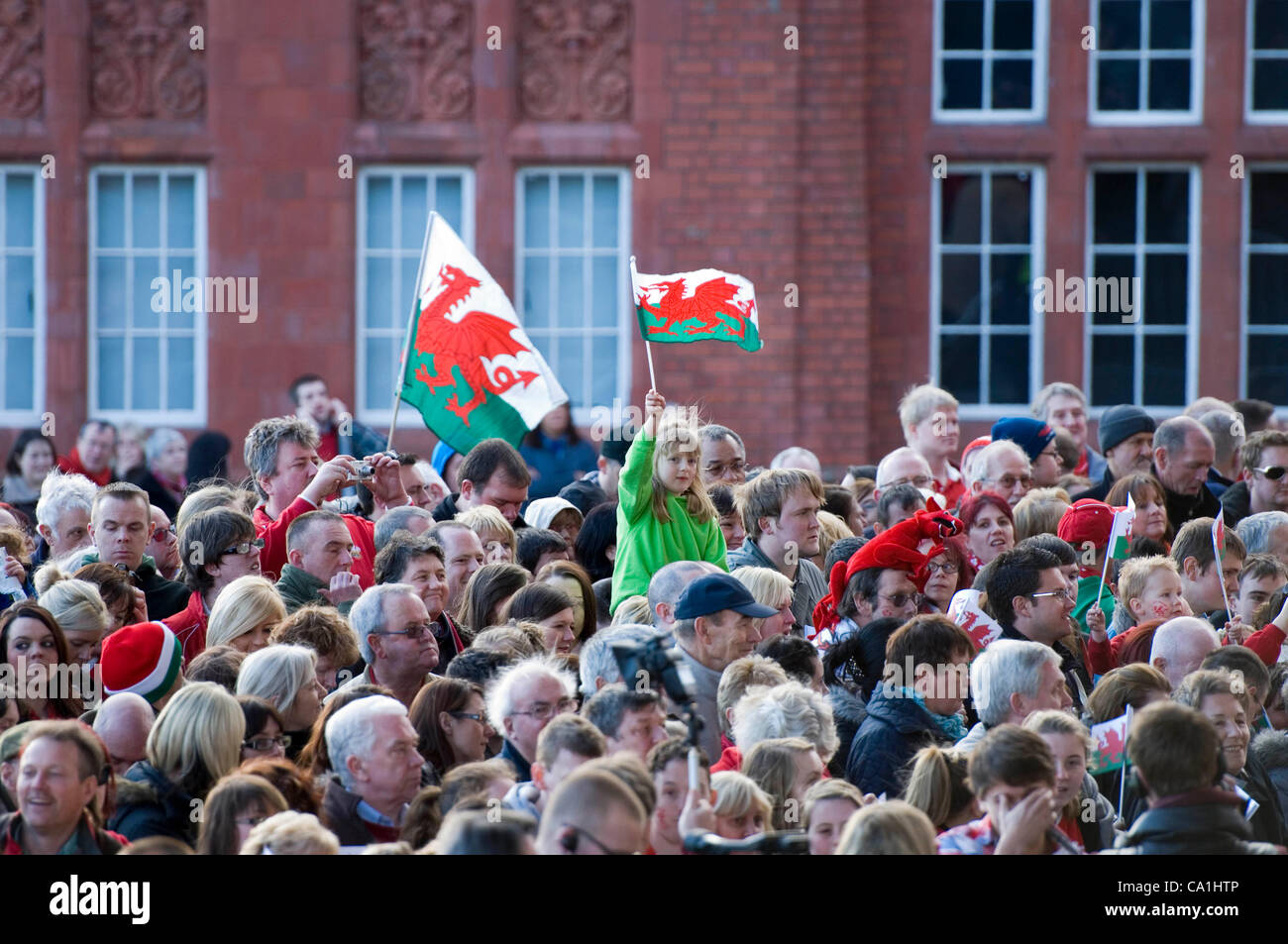 Fans de rugby gallois en regardant l'équipe de rugby gallois célébrer remportant le Grand Chelem dans le tournoi des Six Nations de rugby à l'Senydd dans la baie de Cardiff. Banque D'Images