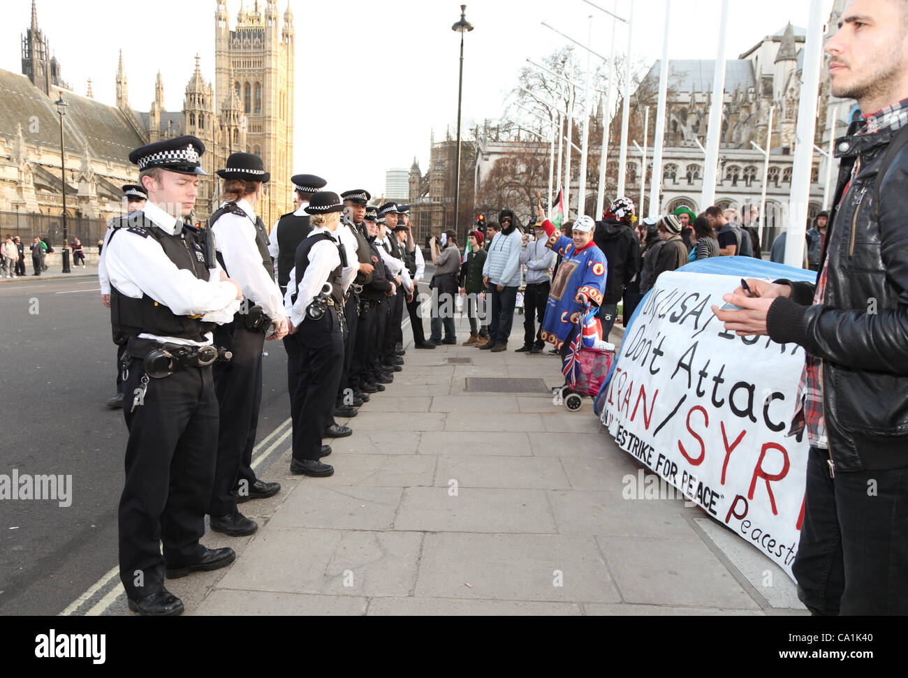 Londres, Royaume-Uni, le 20 mars, 2012. Regardez sur la police tandis que les manifestants crier des slogans contre le projet de loi s'accroupir. La loi a été voté à la Chambre des lords. Banque D'Images