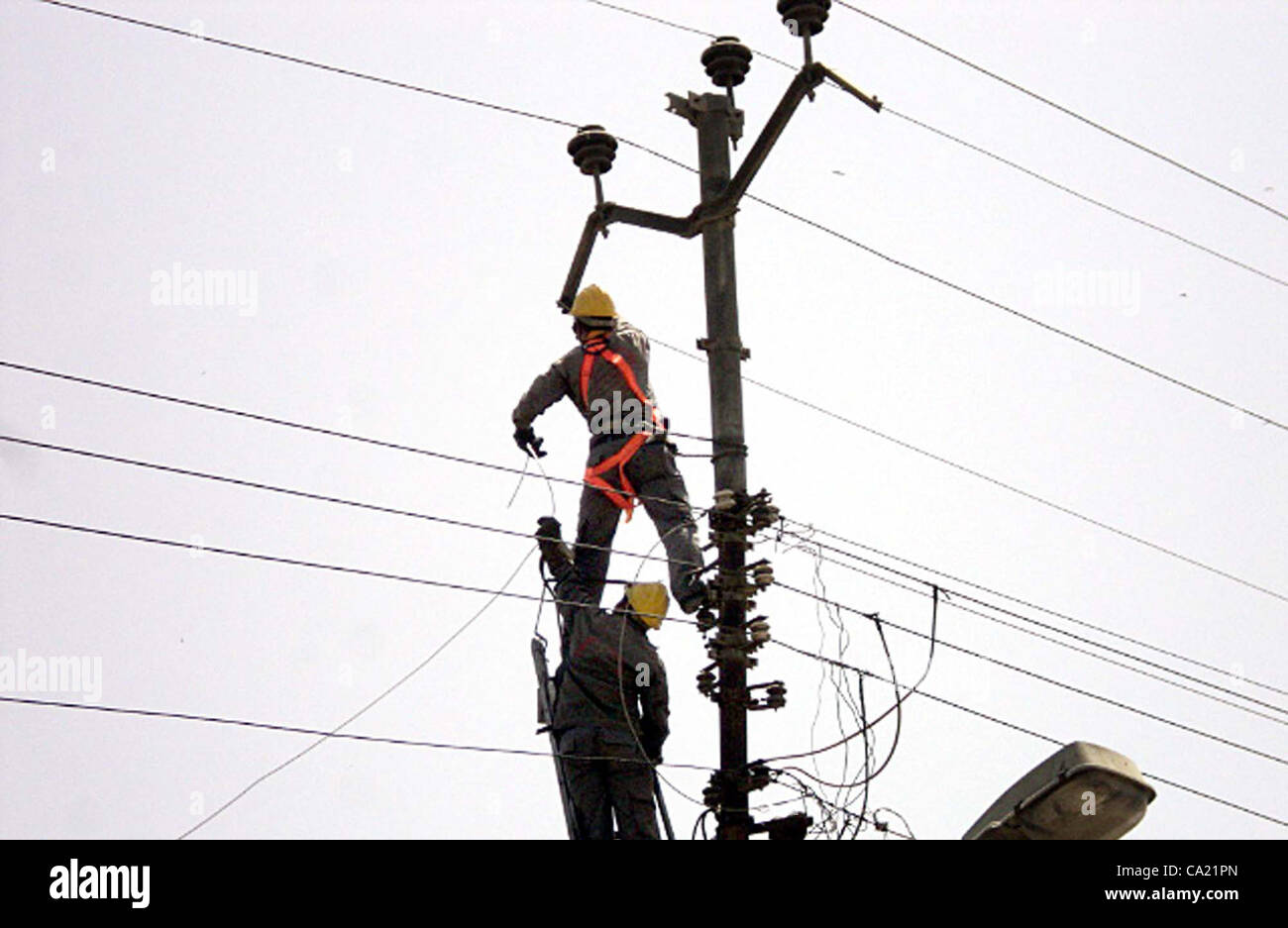 Electric Supply Company (KESC) les travailleurs occupés à travailler à un poteau d'électricité au jardin à Karachi le Jeudi, Mars 22, 2012. Banque D'Images