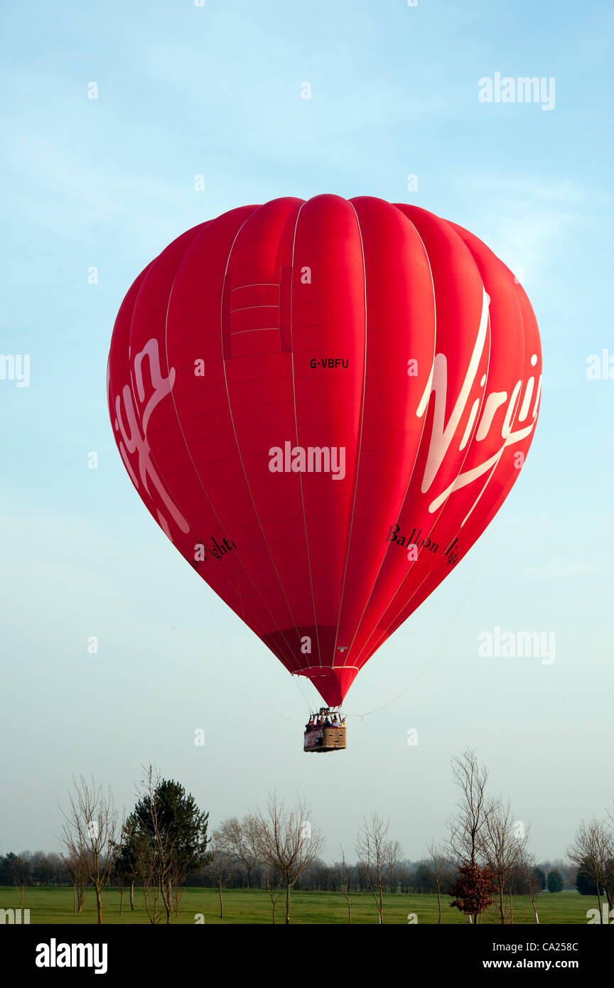 Un voyage en montgolfière décolle juste avant que le soleil se couche dans un beau temps de printemps à Longstanton, près de Cambridge le 23/3/12. La température atteignait 20 degrés Celsius sur comme heure d'été britannique est sur le point de commencer. Banque D'Images