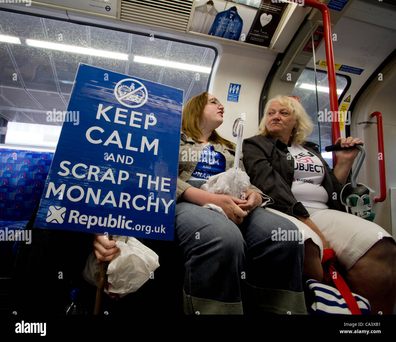 Manifestants républicains anti-monarchie avec des pancartes "ferraille la monarchie" sur un train de métro londonien, le 3 juin 2012, se dirigeant vers une manifestation contre la monarchie et les célébrations du Jubilé à Londres au Royaume-Uni Banque D'Images