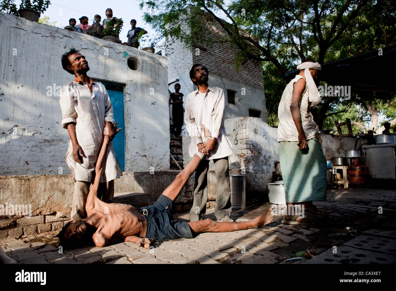 23 mai 2012 - New Delhi, Inde - trois toxicomanes affirment avec d'autres toxicomanes dans l'escalier (pas sur la photo) sur l'opportunité d'aller de KARAN YADAV, qui vient d'être corps mort à plus d'un terrain solide, loin des mouches, à la Yamuna Bazar. Yadav est mort d'une overdose à seulement quelques minutes avant. Le bazar est une zone de rassemblement fo Banque D'Images