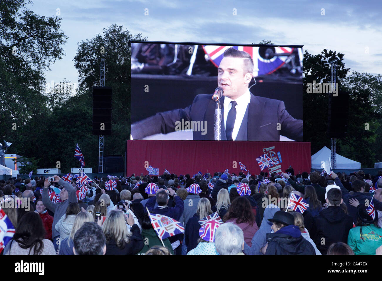 Londres, Royaume-Uni. Le 4 juin 2012. Fans de Londres, profitant de Robbie Williams comme il divertit-les sur le grand écran dans le parc de St James Concert pour célébrer le Jubilé de diamant de la Reine. Banque D'Images