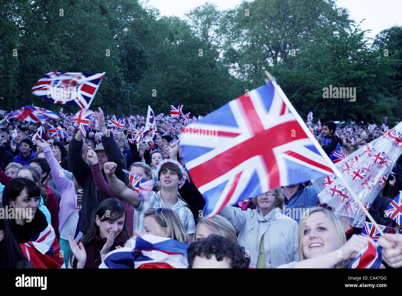 Londres, Royaume-Uni. Le 4 juin 2012. Fans de tous les âges à regarder et apprécier le Concert pour célébrer le Jubilé de diamant de la reine sur les grands écrans à St James's Park. Banque D'Images
