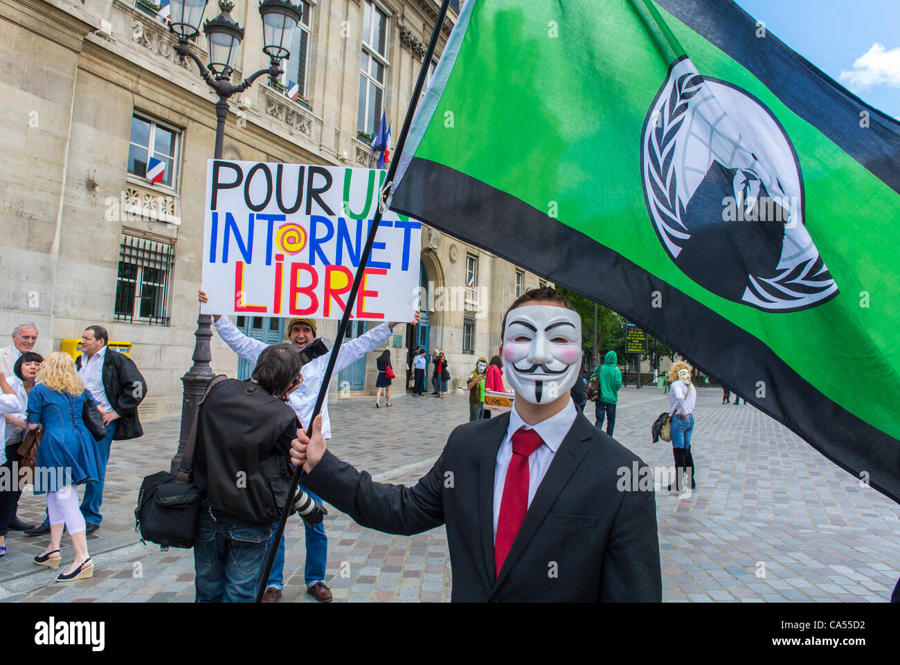 Les militants d'une loi anti-ACTA sur les accords Internet, qui s'opposent au contrôle des communications et à la censure des réseaux Internet, qui tiennent des signes et portent des masques lors d'une manifestation à Paris, protestent contre le libre-échange Banque D'Images