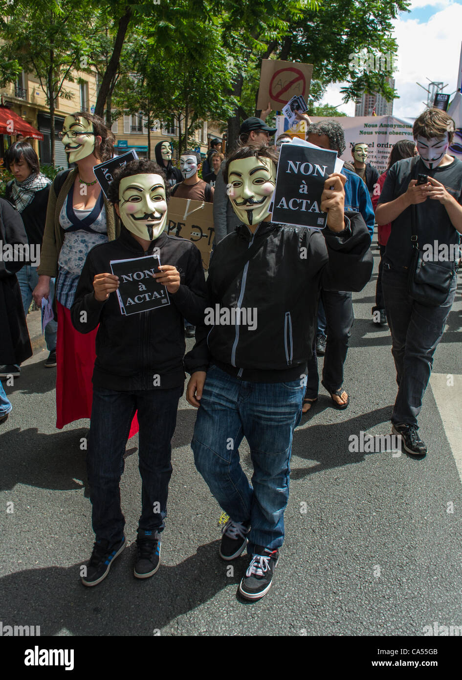 Des militants d'un Anti- Accords Internet ACTA droit, qui s'opposent à la censure des communications et des réseaux internet, tenant pancartes, et portant des masques, lors d'une manifestation à Paris, France, Banque D'Images