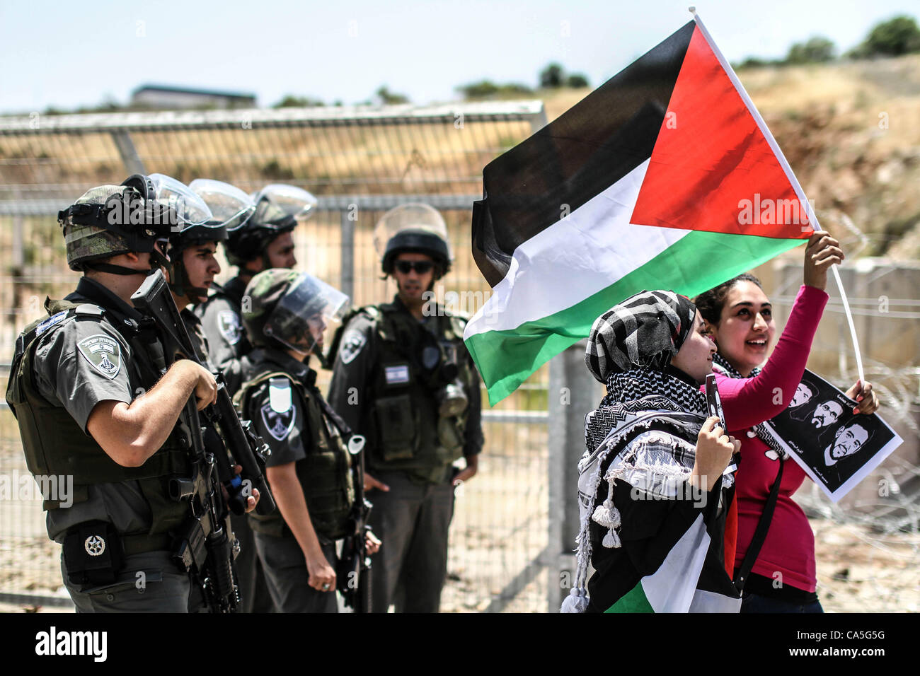 Le 11 juin 2012 - Ramallah, Cisjordanie, territoire palestinien - manifestants palestiniens femelle tenir photos du joueur de football palestinien Mahmud Sarsak (R) et des prisonniers Akram Rikhawi (C) et Samir Al-Baraka lors d'une démonstration en face de la prison d'Ofer, près de la ville de Ramallah, en solidarité Banque D'Images