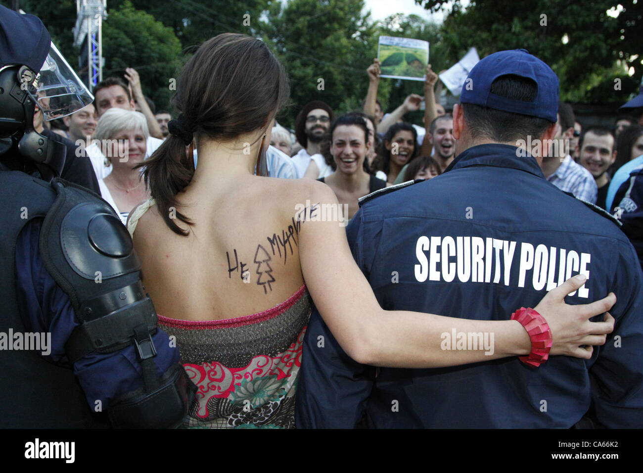 Femme avec un slogan démonstrateur protestation écrite sur son épaule en mettant son bras autour de l'épaule d'un policier. Sofia, Bulgarie, 14/06/2012. Credit : Johann Brandstatter / Alamy Live News Banque D'Images