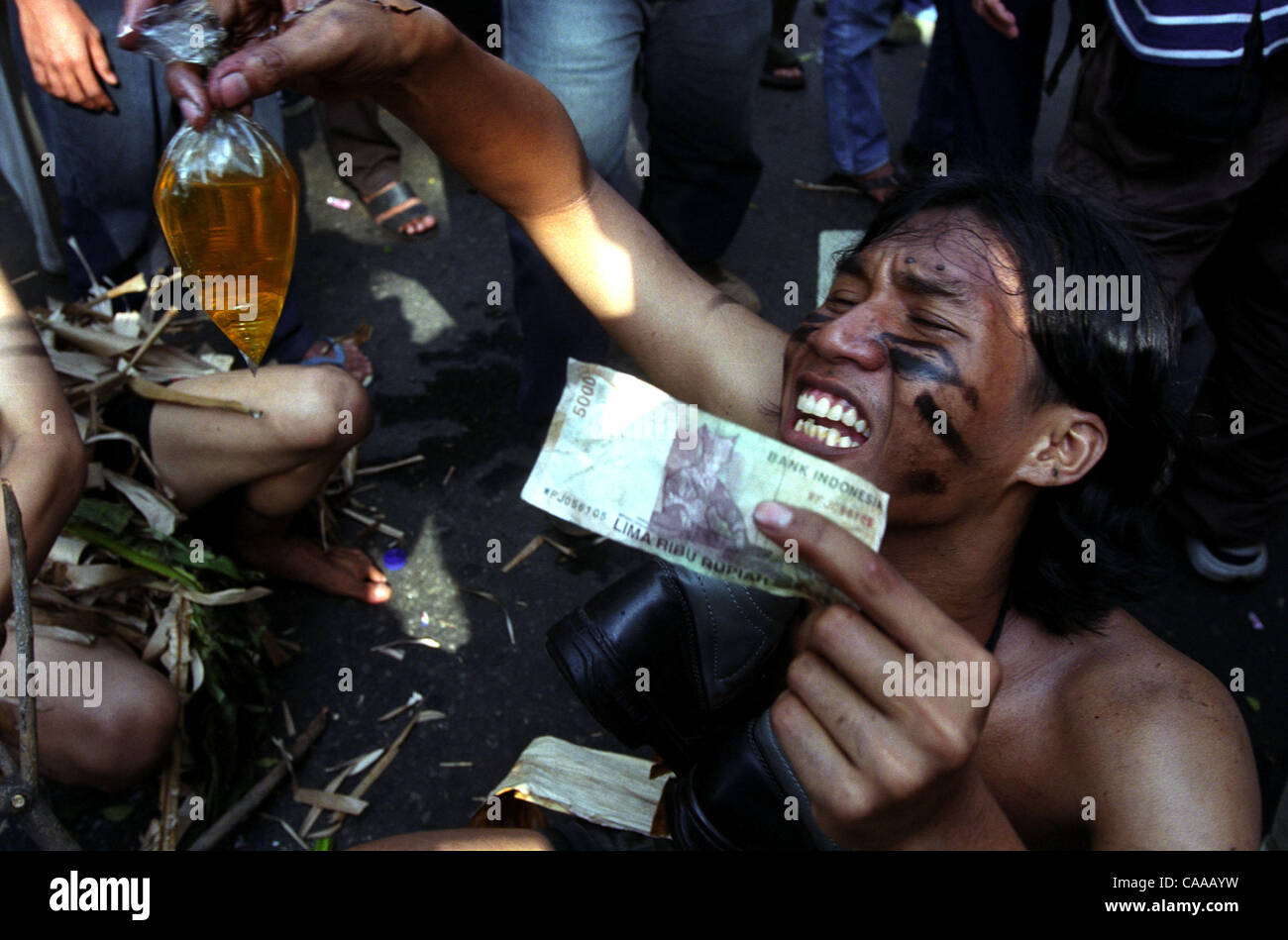 Jan 10, 2003 ; Jakarta, Indonésie ; un protestataire est titulaire d'un projet de loi note et un sac en plastique rempli d'essence pour symboliser l'augmentation de carburant. Les manifestants se rassemblent devant le palais national indonésien pour protester contre l'augmentation de carburant par le Président Megawati Sukarnoputri. Banque D'Images