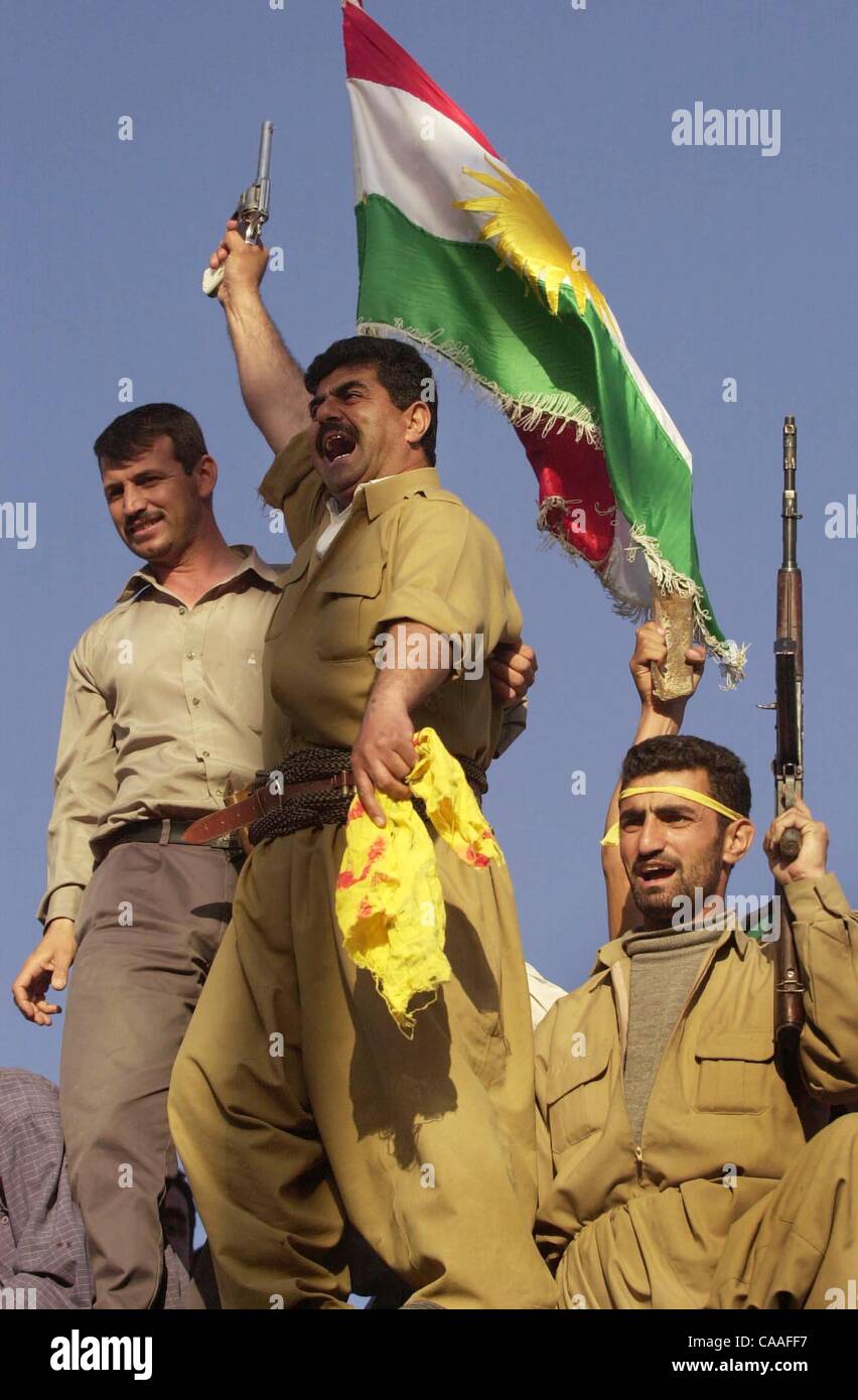 (Publié le 04/11/2003, A-1 ; fin de SignOn Gallery : 30/12/2003) NC KIRKOUK x012 .......... Le 10 avril 2003, Kirkouk, Irak ......est fier de brandir le drapeau Kudistan et tirer leurs pistolets et fusils en l'air Kurdishmen de Kirkouk après avoir détruit une statue de 25 pieds de hauteur du Président Saddam Hussein Banque D'Images