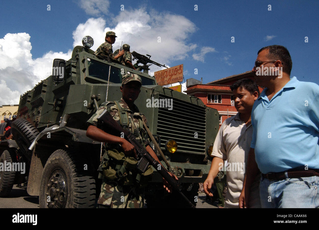Katmandou, Népal, 10 septembre 2003 : promenade piétonne népalais en passant un véhicule blindé dans la rue principale de Katmandou. La violence et la protestation ont grimpé au Népal après la lutte contre la guérilla maoïste pour abolir la monarchie. Des milliers de partisans des cinq principaux partis politiques ont été détenus comme Banque D'Images