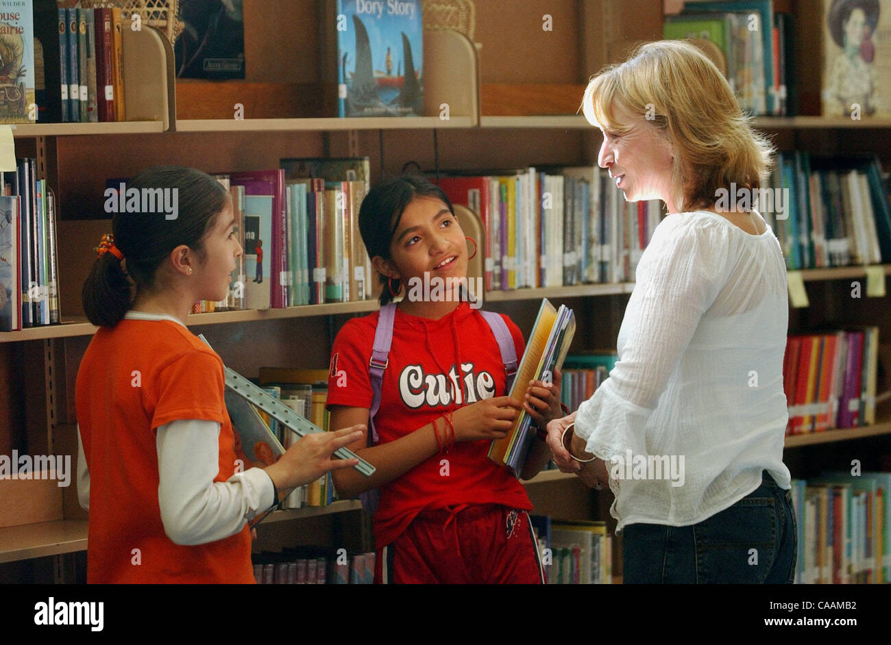 À l'ouest du district scolaire de Contra Costa Assistant de bibliothèque de l'école primaire Maria Chavez parle avec Downer primaire Laura Hurtado, 9, gauche, et Teresa Blanquel, 11, le vendredi 12 mars, 2004 dans la bibliothèque de l'école. Chavez propose cinq écoles primaires dans le district. (Journaux de Contra Costa/Jo Banque D'Images