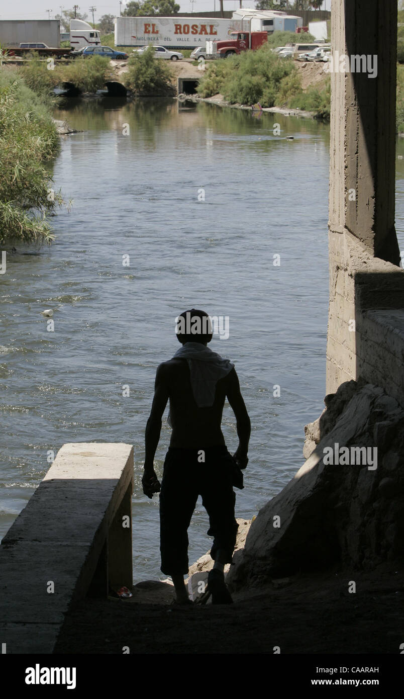 Une très mince jeune homme tatoué va sous un pont en béton sur la très pollué la rivière Rio Nuevo (Nouveau) dans la région de Mexicali, Mexique pour l'injection de drogues intraveineuses. C'est juste au sud de la frontière, où la rivière s'ouvre après avoir été enfermé dans le béton au cours de sa circulation à travers la ville. U/T photo CHARLIE N Banque D'Images