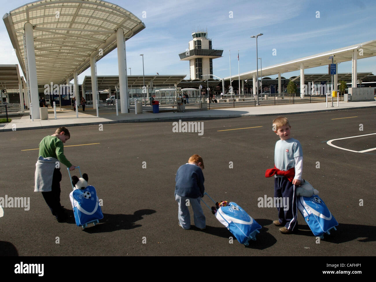 Edward le poisson, 7 poissons, 4, Johnathan, et Peter le poisson, 5, n'auront pas à payer les $25 par sac frais pour bagages supplémentaires que certaines compagnies aériennes imposent aux passagers. Les frères de poissons font leur chemin au terminal, de l'Aéroport International d'Oakland Mercredi, 27 février 2008 à Oakland, Californie (Joanna Jhanda/ Banque D'Images