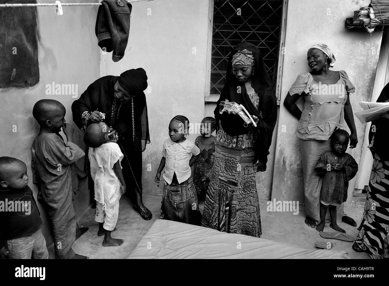 2 janvier 2011 - Kano, KANO, NIGERIA - une mère, droite, refusant le vaccin contre la polio pour ses enfants est annulé par JOSEPHINE KAMARA, l'agent de l'UNICEF chargé de la mobilisation sociale pour la campagne de vaccination contre la poliomyélite, à gauche, en noir, cinq vaccine les enfants contre la polio. Un vaccinateur au milieu Banque D'Images