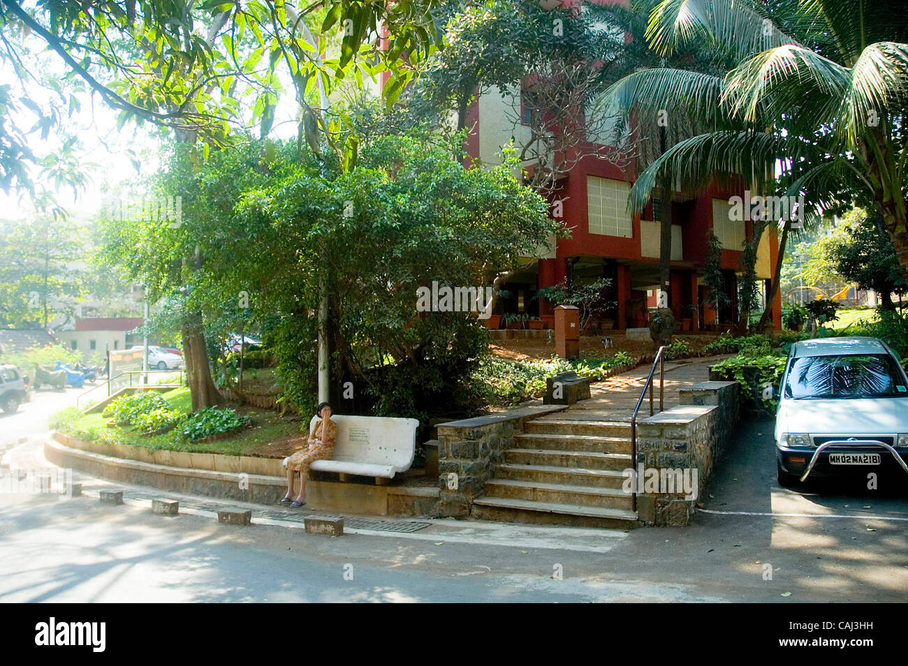 Une femme Parsi se détend sur un banc à l'ACFGAM Baug, une des nombreuses colonies Parsi de Bombay. Banque D'Images