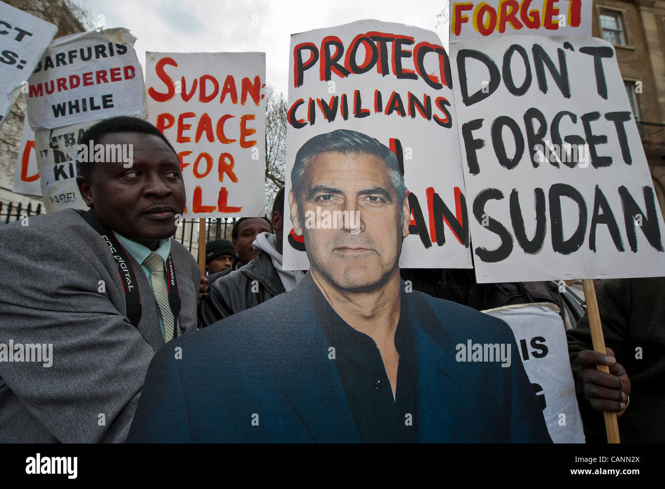 Un carton de George Clooney à une protestation au nom de la nuba de demander l'intervention du gouvernement britannique pour protéger contre les violations des droits de l'homme au Soudan et au Darfour et à traduire les responsables du meurtre de Awadiya Aajabna à la justice. Downing St, Whitehall, Londres, UK, 31/3/12 Banque D'Images