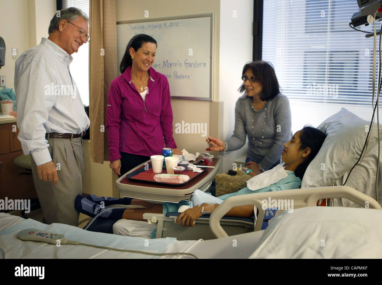 4 mars 2012 - Memphis, Tennessee, États-Unis - 040812WIRE - plomb pour l'INTÉRIEUR PAGE - coeur - 4 mars 2012 - récupération du jour après une chirurgie cardiaque, Dunia, Peraza-Ramirez est réconfortée par Gwen Wolford, centre, le Dr Ron Coleman, Christian Colamonici, infirmière et traducteur. ''Ron vous dira, la main de Dieu a Banque D'Images