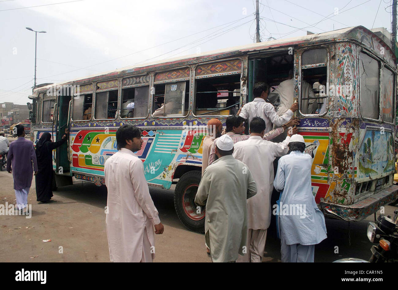 Passagers essaient de conseil sur une voiture qu'ils sont confrontés à des problèmes en raison de la non-disponibilité des transports publics pendant la grève du bourrage de roue sur l'appel de Karachi Ittehad Transport contre l'augmentation du prix des produits pétroliers le mardi 10 avril, 2012. Banque D'Images