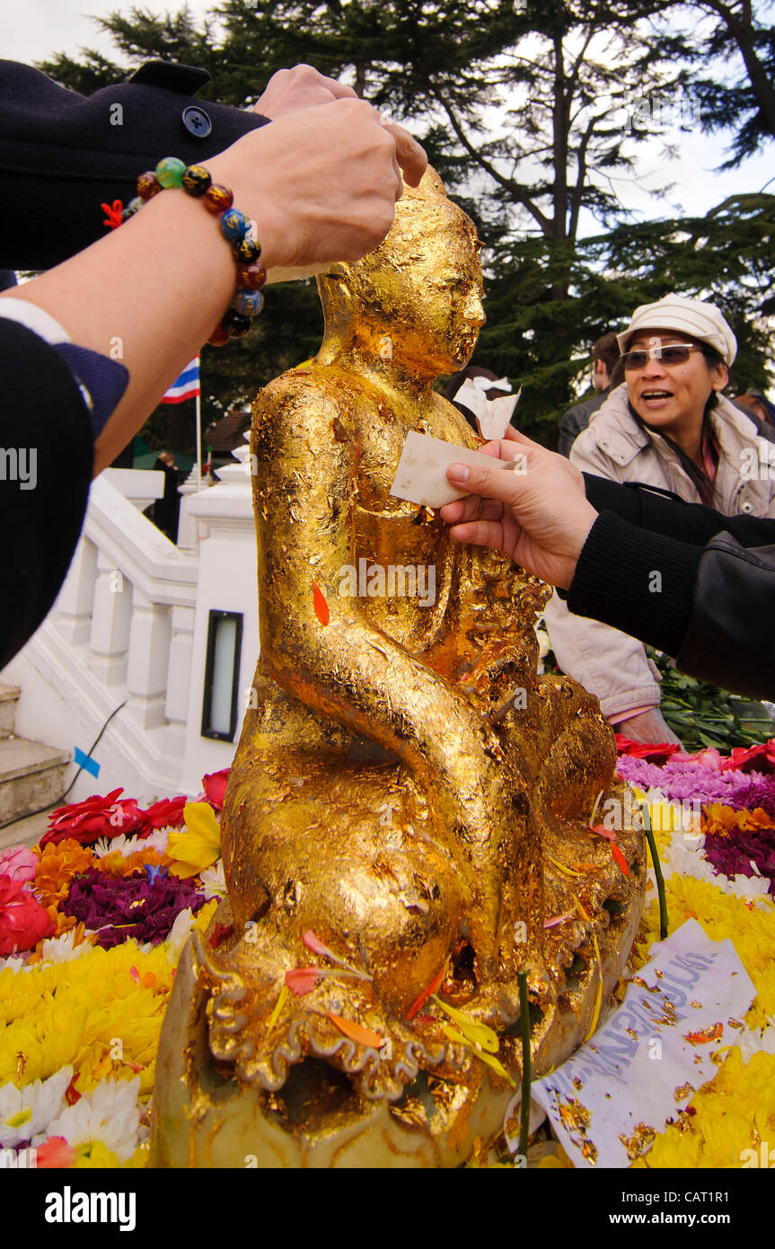 Wimbledon, Londres, Royaume-Uni, 15 avril 2012. À la Thai temple de Wat Buddhapadipa pour célébrer Songkran, Nouvel An thaï, un sacrifice de la feuille d'or est appliqué à une statue de Bouddha. Banque D'Images