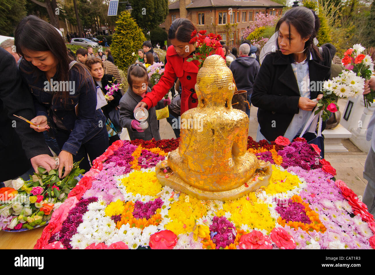 Wimbledon, Londres, Royaume-Uni, 15 avril 2012. À la Thai temple de Wat Buddhapadipa pour célébrer Songkran, Nouvel An thaï, un sacrifice de la feuille d'or est appliqué à une statue de Bouddha. Banque D'Images