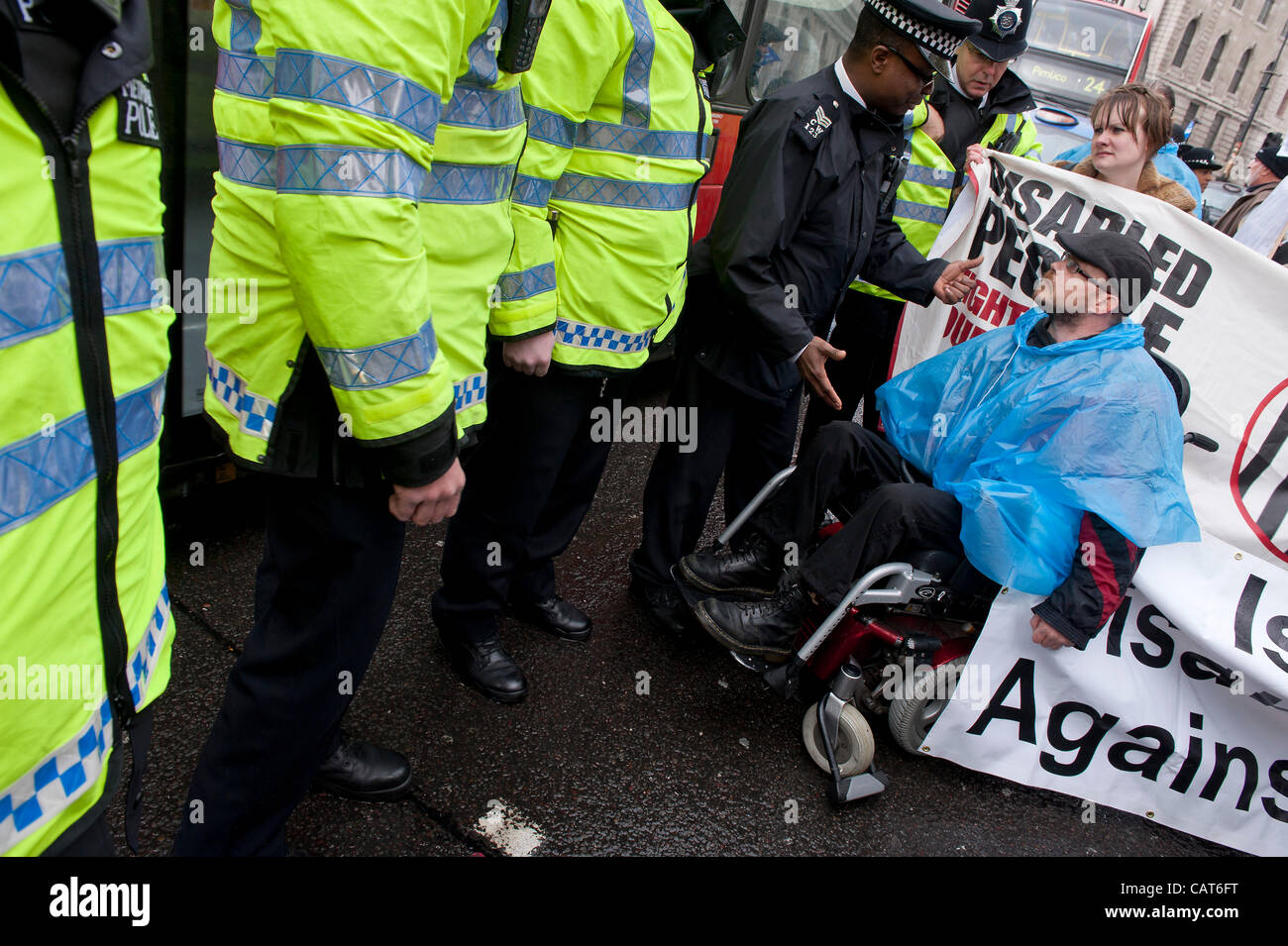 Tentative de la police d'effacer la route. Les membres de l'ATLC et mars UKUncut de Leicester Square à Trafalgar Square où ils bloquent la jonction avec le Strand. Ils protestent contre des coupes dans les usines Remploy et le bien-être du projet de loi de réforme en général. Londres, Royaume-Uni, 18 avril 2012. Banque D'Images