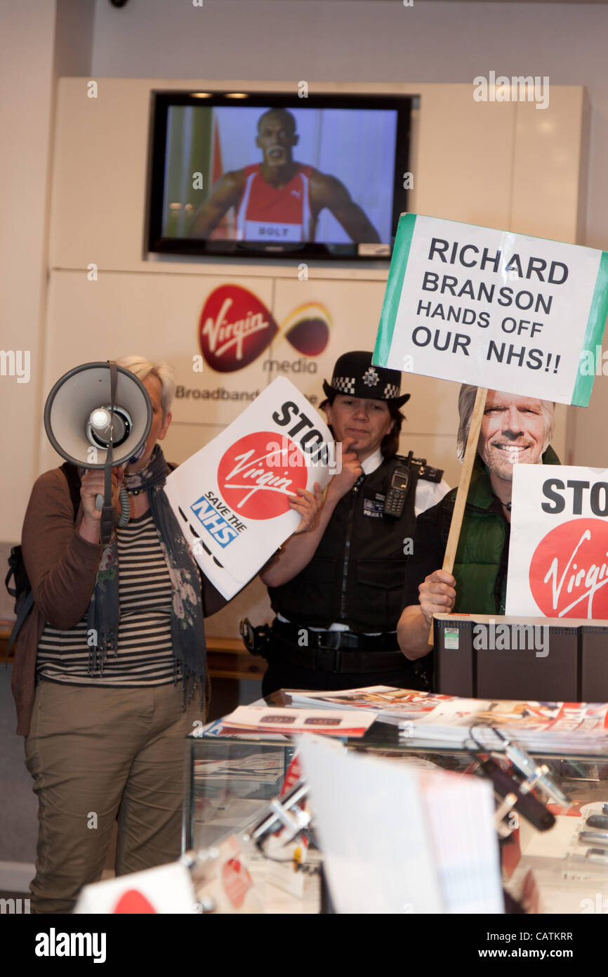 Les policiers parlent aux manifestants et leur demander de quitter le magasin Virgin. Environ 30 manifestants ont protesté devant le Virgin stores sur Oxford Street contre leur participation à la privatisation de la NHS. Banque D'Images