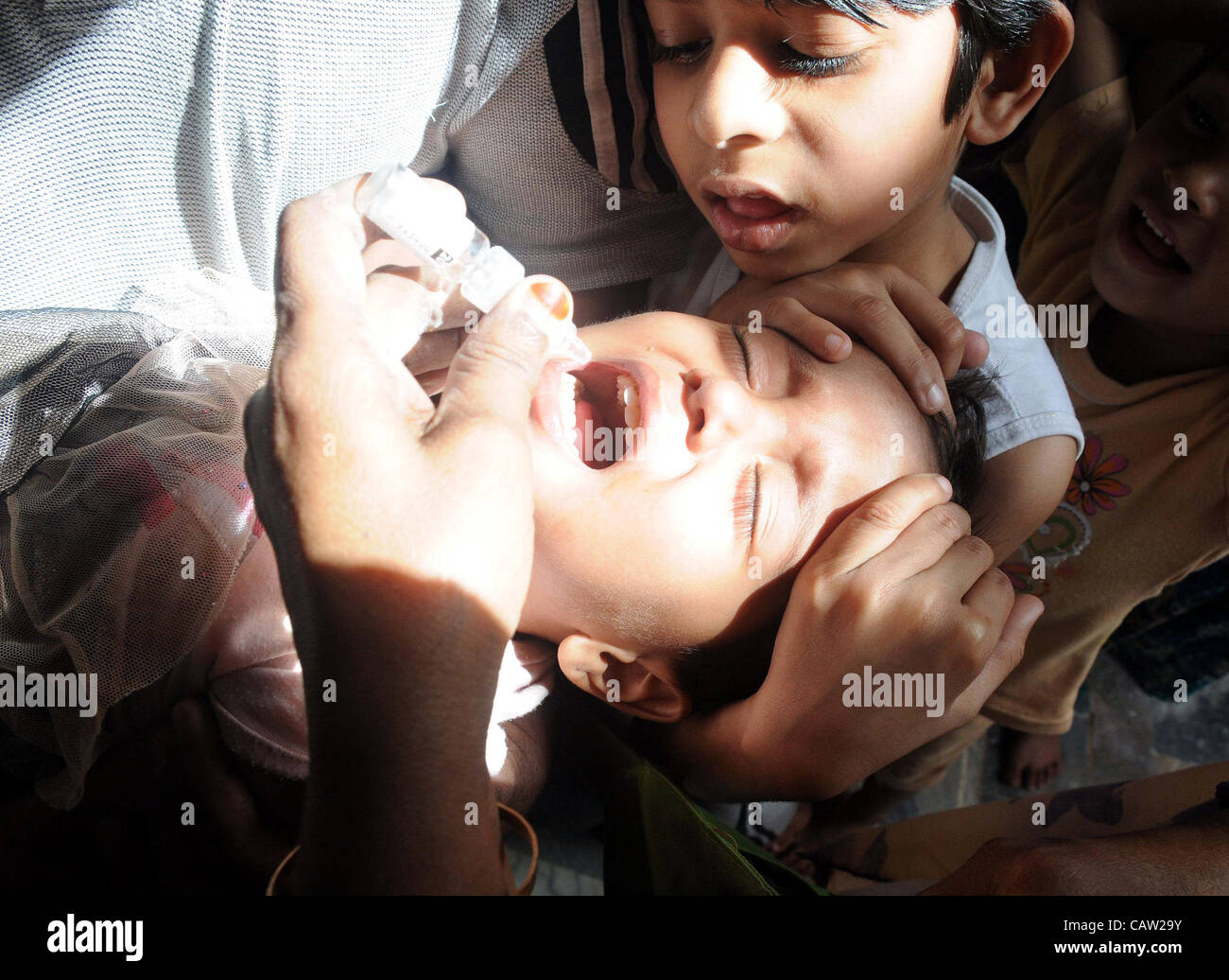 Un travailleur de la santé administre le vaccin contre la poliomyélite chute à un enfant pendant trois jours de la campagne d'éradication de la poliomyélite dans la région de Karachi le Lundi, Avril 23, 2012. Banque D'Images