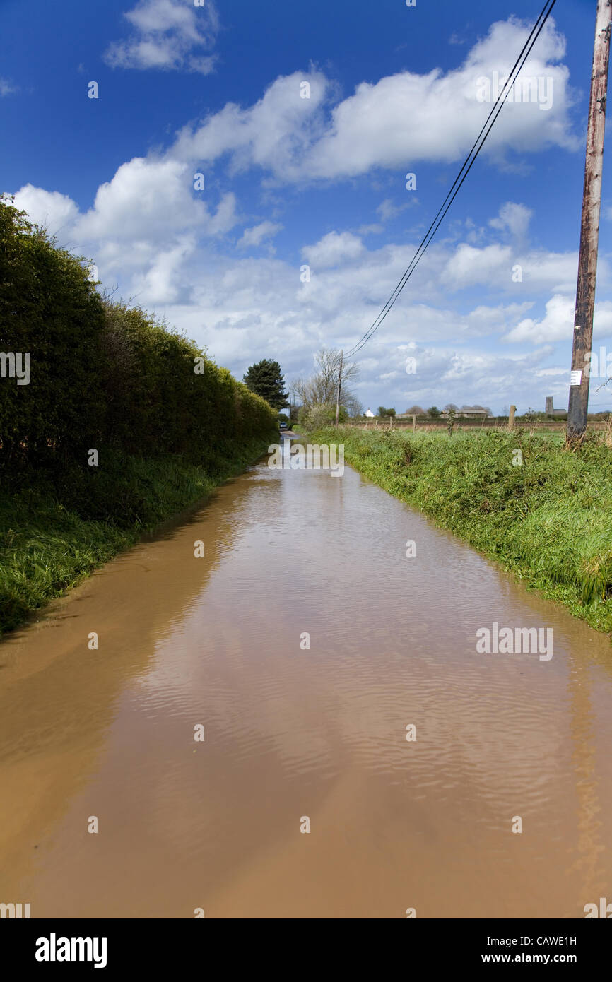 Fortes pluies à l'origine des inondations dans la région de North Norfolk, UK le jeudi 26 avril 2012. Sur la photo, la crue des eaux boueuses d'un chemin de campagne. Banque D'Images