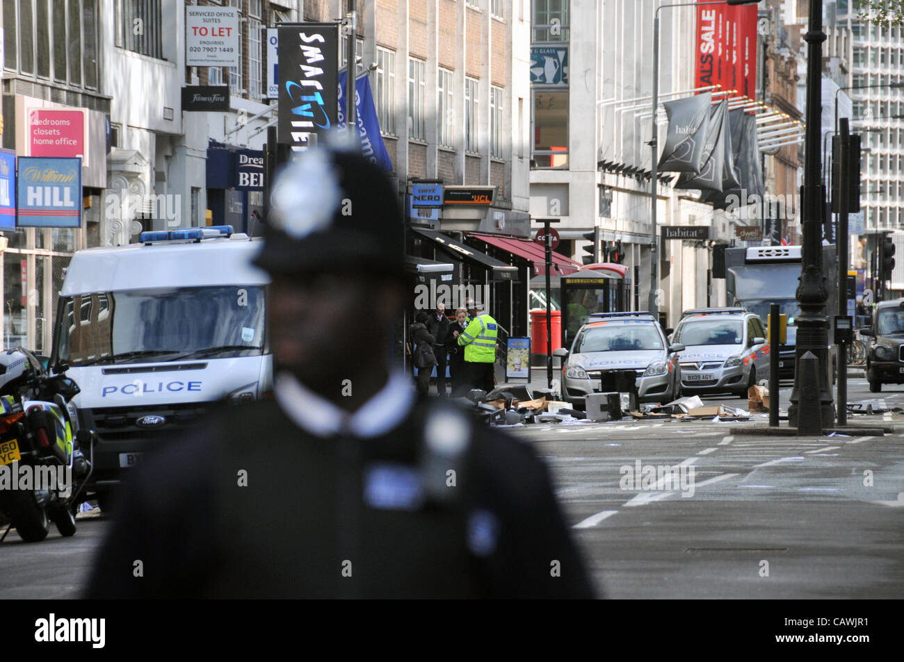 Londres, Royaume-Uni. 27 avril, 2012. Agent de police garde la scène de la prise d'otages d'aujourd'hui alerte sur Tottenham Court Road, Londres. Banque D'Images