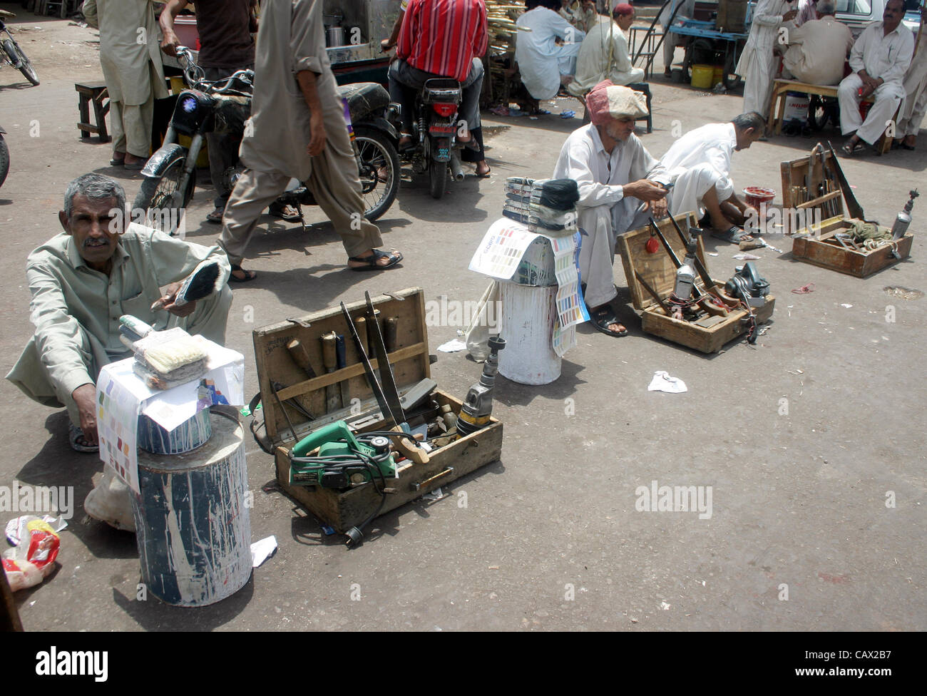 Travail sans emploi s'asseoir à une attente de la route pour leur emploi, à la veille de la fête du Travail à Karachi le lundi 30 avril 2012. Banque D'Images