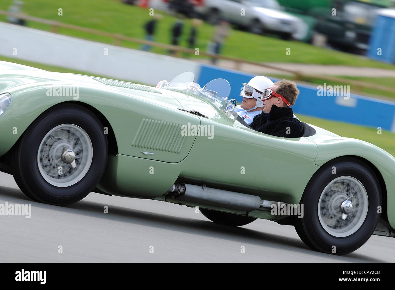 6 mai 2012, le circuit de course de Donington Park, Royaume-Uni. Stirling Moss conduit sa race gagner 1952 Jaguar C-Type XKC 005, avec un jeu-concours en tant que passager. Stirling a reçu une permission spéciale pour porter cette période, casque et lunettes. Banque D'Images