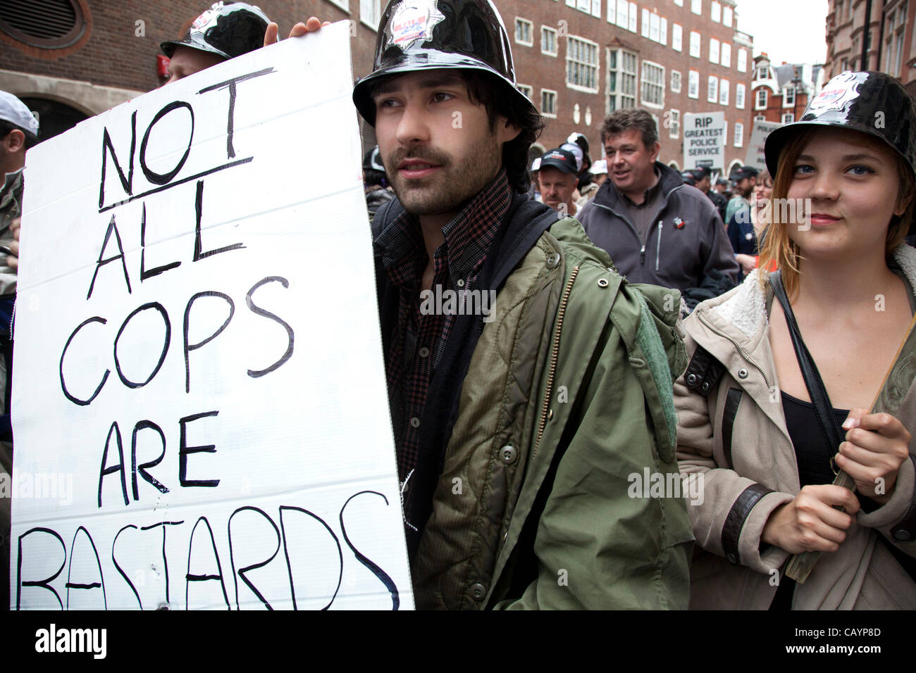 Occupy LSX membres à l'appui de la police avec une pancarte "pas tous les flics sont des bâtards" et portant des casques de police en plastique. Un jour où 400 000 travailleurs du secteur public en grève plus de réductions, soldes et pensions, environ 30 000 agents de police hors service, ont défilé dans la capitale contre le projet. Banque D'Images