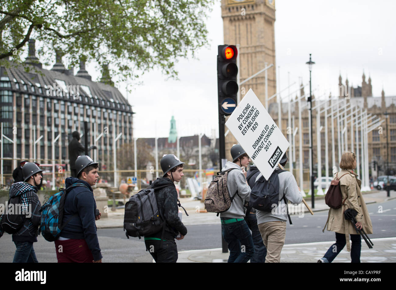 10 mai 2012 Le centre de Londres. Les élèves portant des casques de police en plastique et portant une plaque et de l'abandonné marchant à travers la place du Parlement, juste après que les policiers avaient terminé leur protestation contre 20  % de réduction pour le budget de la police. Banque D'Images