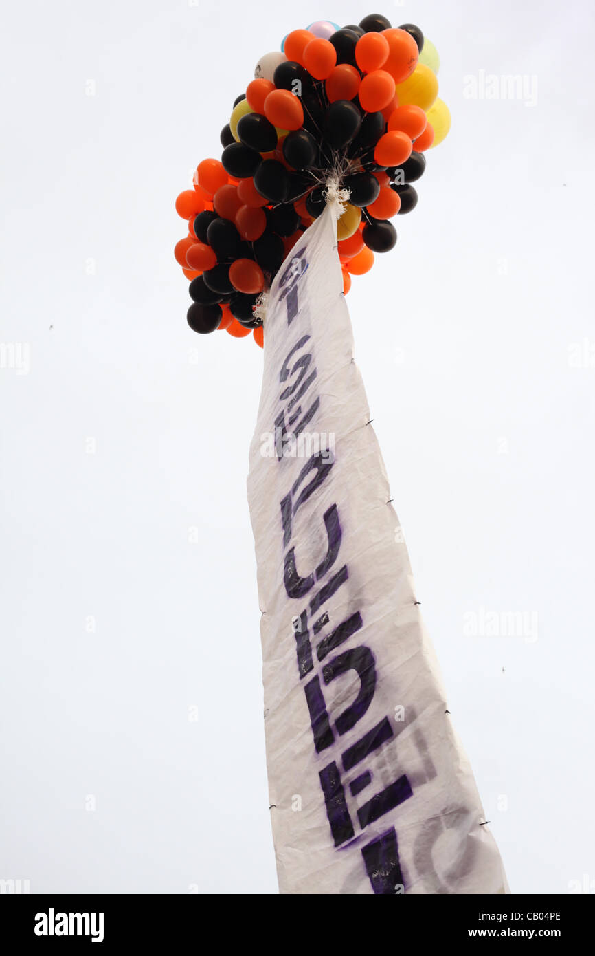 Une enseigne apposée à un groupe d'heluim ballons sont mis à flot à l'occuper de protestation de Madrid à la Puerta del Sol à Madrid, Espagne. 12 mai, 2012 Banque D'Images