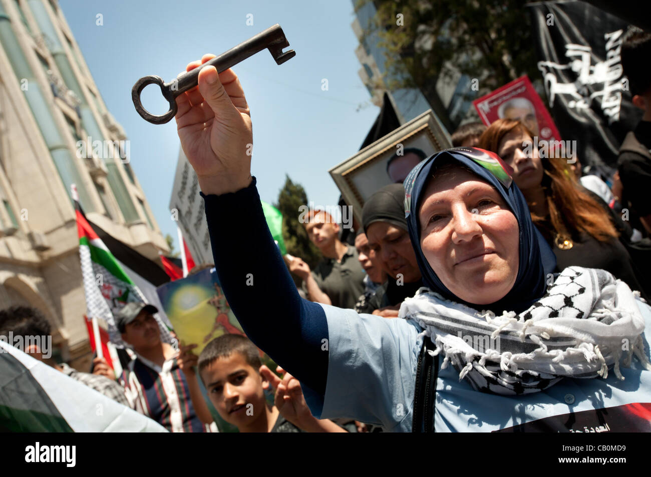 RAMALLAH, dans les territoires palestiniens - 15 MAI 2012 : portant un symbole du droit de retour, une femme palestinienne marches à travers les rues de Ramallah le jour de la Nakba, commémorant la 'catastrophe' que les réfugiés palestiniens expulsés de ce qui est devenu l'état moderne d'Israël en 1948. Banque D'Images