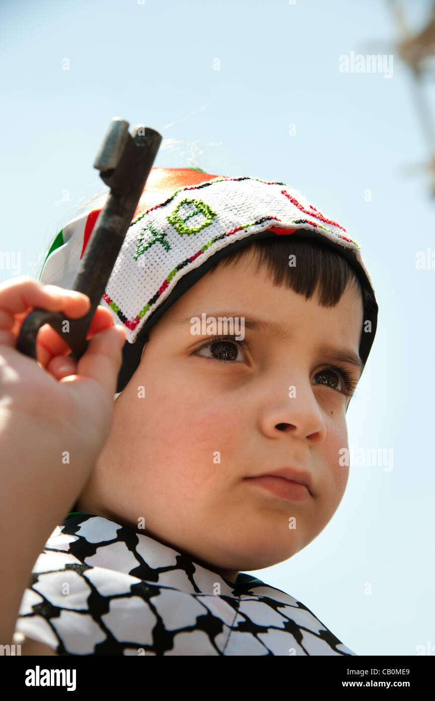RAMALLAH, dans les territoires palestiniens - 15 MAI 2012 : portant un symbole du droit de retour, un enfant palestinien marches à travers les rues de Ramallah le jour de la Nakba, commémorant la 'catastrophe' que les réfugiés palestiniens expulsés de ce qui est devenu l'état moderne d'Israël en 1948. Banque D'Images
